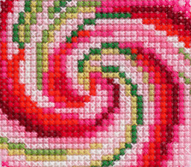 Red, pink and green cross stitch spiral background.