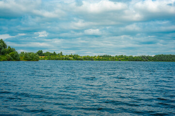 River bay, forest on the shore. A beautiful bay overgrown along the shore with a green forest under a deep blue sky