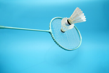 Badminton shuttlecocks and badminton racket on blue background