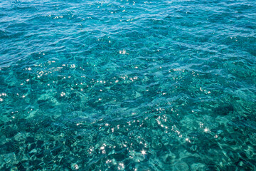 Wavy turquoise sea water surface with shiny sparkles