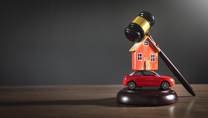 Judge gavel with a house model and toy car on the wooden table.