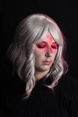 Chica mirando abajo en estudio sobre fondo negro