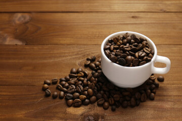 Coffee grains and tea leaves in cup on table