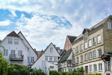 Backyard facades of historic residential buildings in the old town of Flensburg, Germany, cloudy blue sky, copy space