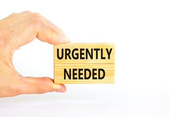Urgently needed symbol. Concept words Urgently needed on wooden blocks on a beautiful white table white background. Businessman hand. Business and urgently needed concept. Copy space.