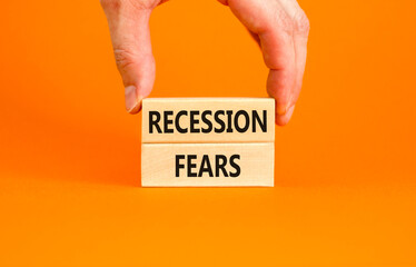 Recession fears symbol. Concept words Recession fears on wooden blocks on a beautiful orange table orange background. Businessman hand. Business and recession fears concept. Copy space.