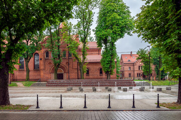 The church of St. Michael the Archangel in Orzegow, Ruda Slaska, Silesia, Poland. Beautiful, renovated temple in neo-roman style from 1911 surrounded by trees with fountain in the foreground.