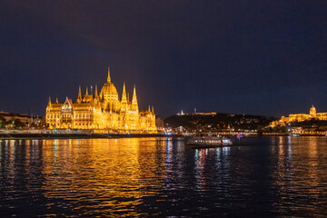 Fototapeta na wymiar Országház, Hungarian Parliament Building, seen from the Danube river at night in Budapest - Wide side on 