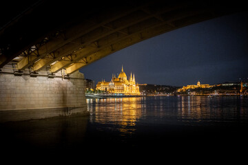 Országház, Hungarian Parliament Building, seen from the Danube river at night framed by Margit híd, bridge, in Budapest