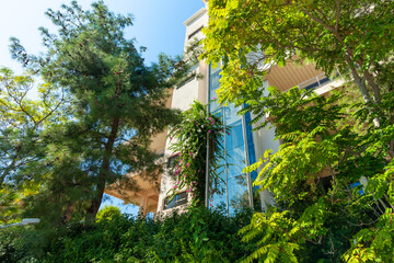 Building embodies an eclectic architectural style and fresh green trees with flowers.