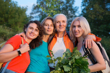 multi generation a group of women friends with backpacks hiking in nature and spending time together. travel tourism concept. Outdoor activities on weekends.