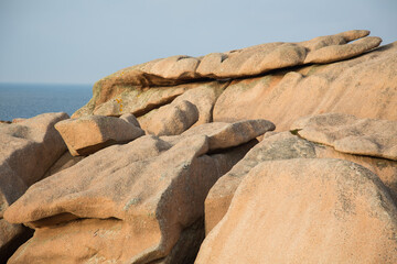Extraordinarily colored and fantastically shaped stones or rock formations weathered by centuries of wind and tide of the the Atlantic-pink granite coast in Brittany, France, close up, nature texture
