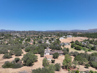 Fototapeta na wymiar Aerial view of dry valley and land with houses and barn in Escondido, San Diego, California
