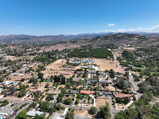 Fototapeta na wymiar Aerial view of dry valley and land with houses and barn in Escondido, San Diego, California