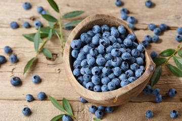 Fresh blueberries in bowl on wooden planks