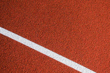 Colorful sports court background. Top view to red field rubber ground with one white line outdoors