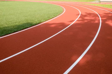 Foto op Aluminium School sports stadium with red artificial rubber ground running tracks white lines on it © vejaa
