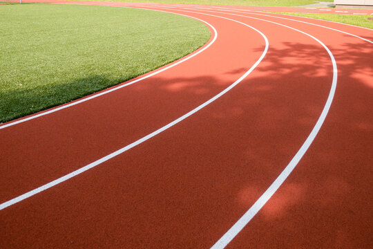 School sports stadium with red artificial rubber ground running tracks white lines on it