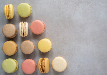 Flat Lay of an Assortment of Pastel Macarons on Concrete Table with Copy Space