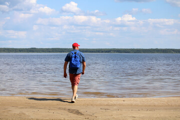 A man walks along the shore of the reservoir.