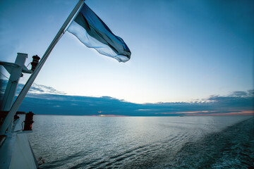 Moving to Tallinn from   Helsinki or Stockholm or Malmo  -   Flag of Estonia onferry  in sunset ...