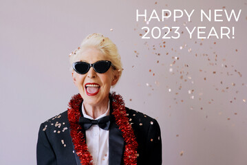 Beautiful stylish mature senior woman in sunglasses and tuxedo celebrating new year. Fun, party,...