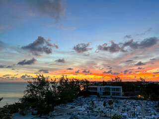 An aerial view of Cemetery Beach on Seven Mile Beach in Grand Cayman Island with a beautiful sunset.