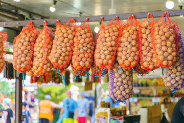 Small bags of walnuts hanging in the market for sale
