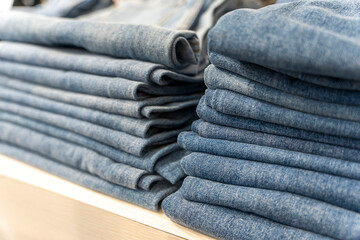 a stack of blue jeans on a shelf in the store. fashion clothing store