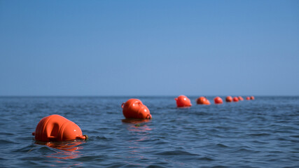 Orange floating buoys in the sea. Human life saving concept. Blue sky.