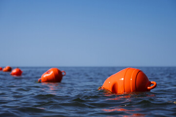Orange floating buoys in the sea. Human life saving concept. Blue sky.