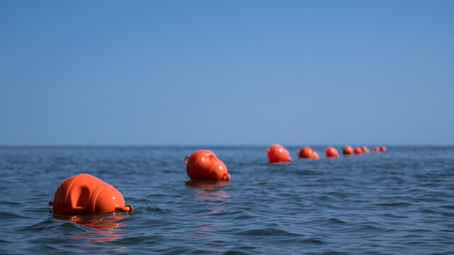 Orange floating buoys in the sea. Human life saving concept. Blue sky.