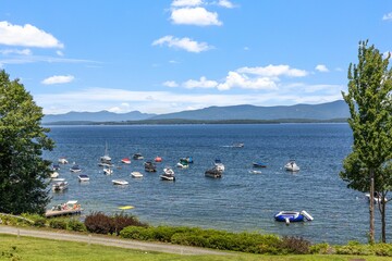 Aerial view of floating boat in lake Winnipesaukee in background of mountains
