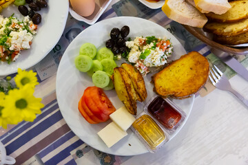 Breakfast at the hotel of tomatoes, cucumbers, potatoes, salad, cheese, olives and bread.