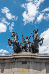 Fototapeta na wymiar London, UK - July 4, 2022: Frontal closeup of Boudiccan Rebellion statue showing Celtic Queen attacking with a horse span under blue cloudscape. NW corner of Westminster bridge