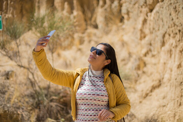 Mujer turista tomando selfies con su teléfono en un cañon. Concepto de turismo, viajes, vacaciones