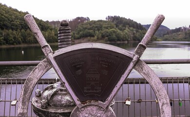 Closeup of an old white helm with a beautiful lake amid a forest in the background