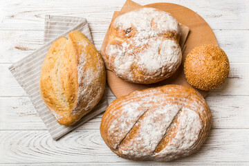 Assortment of freshly baked bread with napkin on rustic table top view. Healthy unleavened bread. French bread