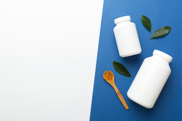 Omega-3 capsules lie in white bottle on a table with green leaves background. Fish oil tablets. Biologically active additives. omega 6, omega 9, vitamin A, E, D, vitamin D3 top view with copy space