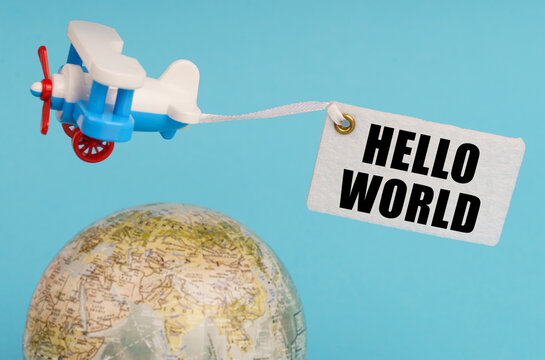 On a blue background, a globe and an airplane with a sign - hello world