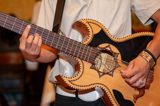 Closeup shot of the hands of a person playing bajo sexto