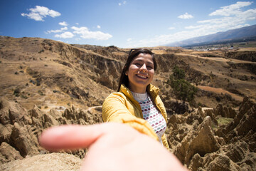 Mujer turista sonriendo tomándose un selfie en lo alto de una montaña en sudamérica (perú)...