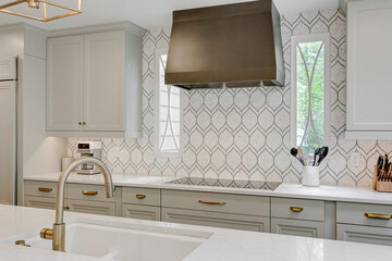 Luxury interior staged kitchen white stone countertops decor stools ceramic tile backsplash modern...