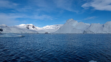 Iceberg floating at the base of snow covered mountains in Cierva Cove, Antarctica