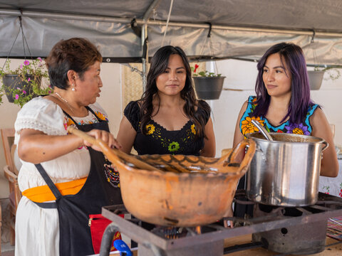 Indigenous mom speaks to daughters as she cooks food