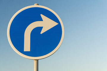 Road sign blue right turn signal on sky background