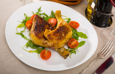 Tasty fried chicken legs served with arugula on white plate