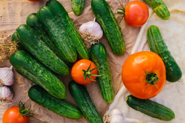 Fresh vegetables on a wooden background. The concept of healthy eating. Cucumbers, tomatoes, garlic, dill. Top view.