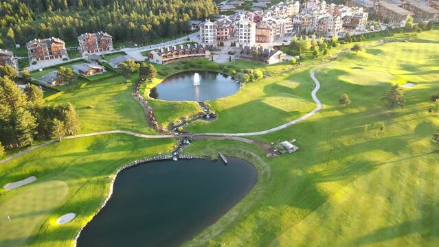 Aerial shot of the Piring Golf playground in Razlog Bulgaria with cars passing on the road