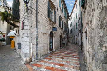 Fototapeta na wymiar A narrow tile and stone alley through the historic medieval old town at Kotor, Montenegro.